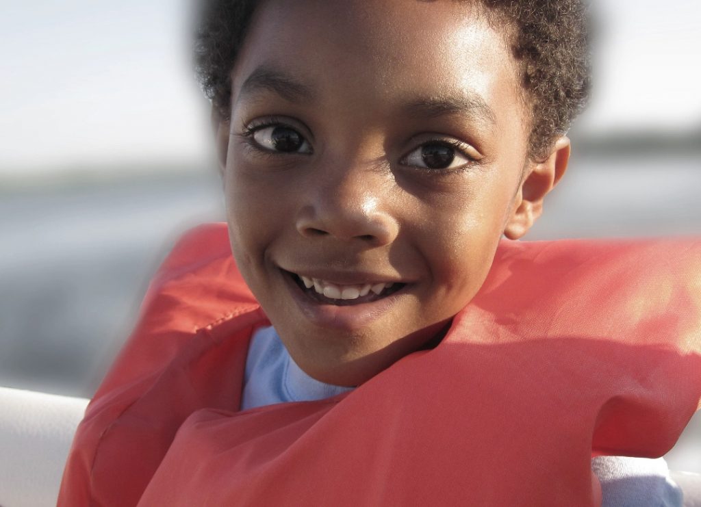 A closeup look of a child wearing a safety jacket for swimming