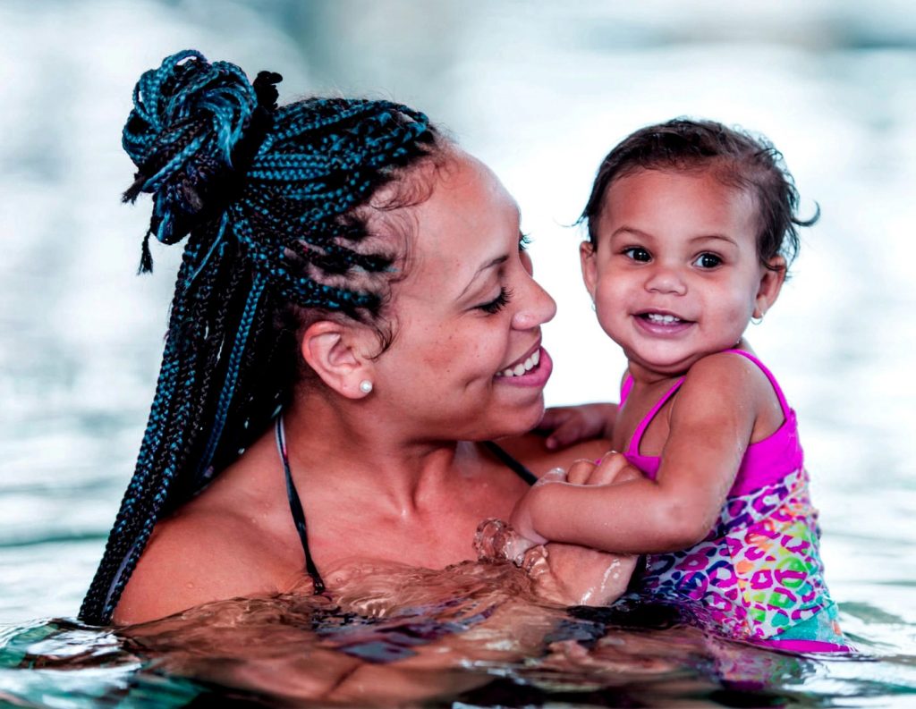 A mother and a child in the swimming pool swimming together
